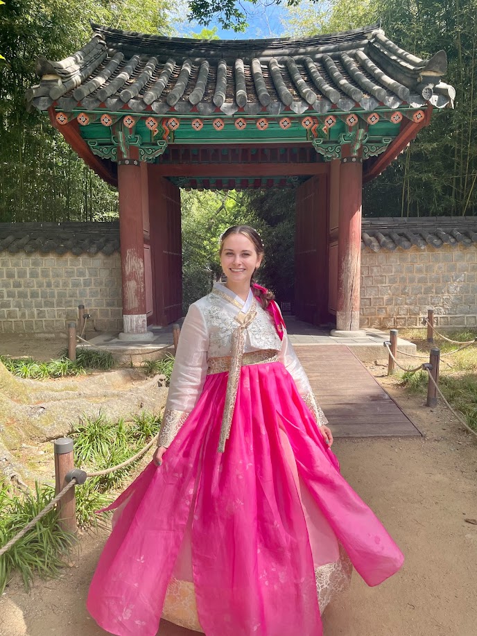 hallie wears hanbok in front of a korean shrine