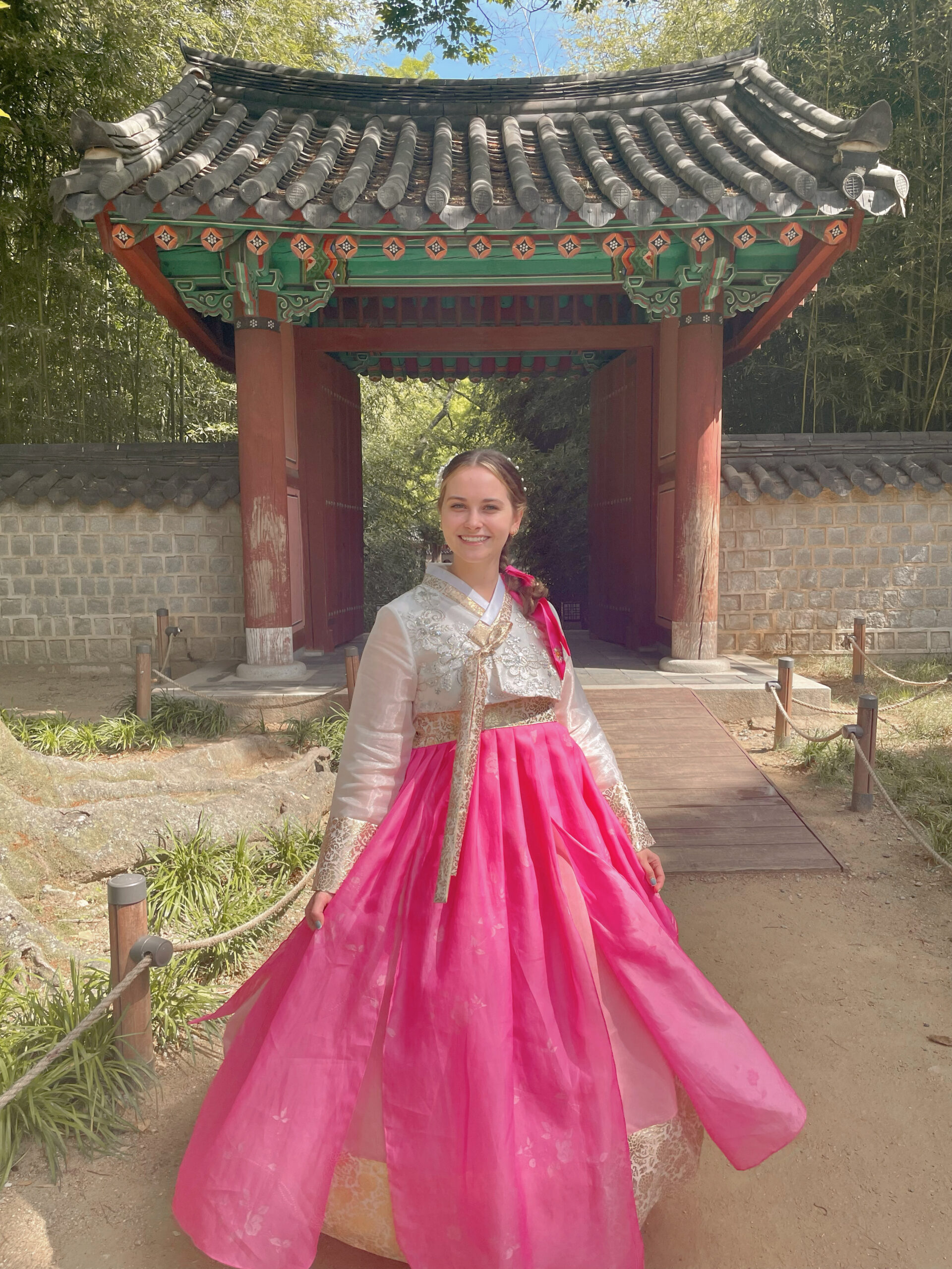 hallie wears hanbok in front of a korean shrine